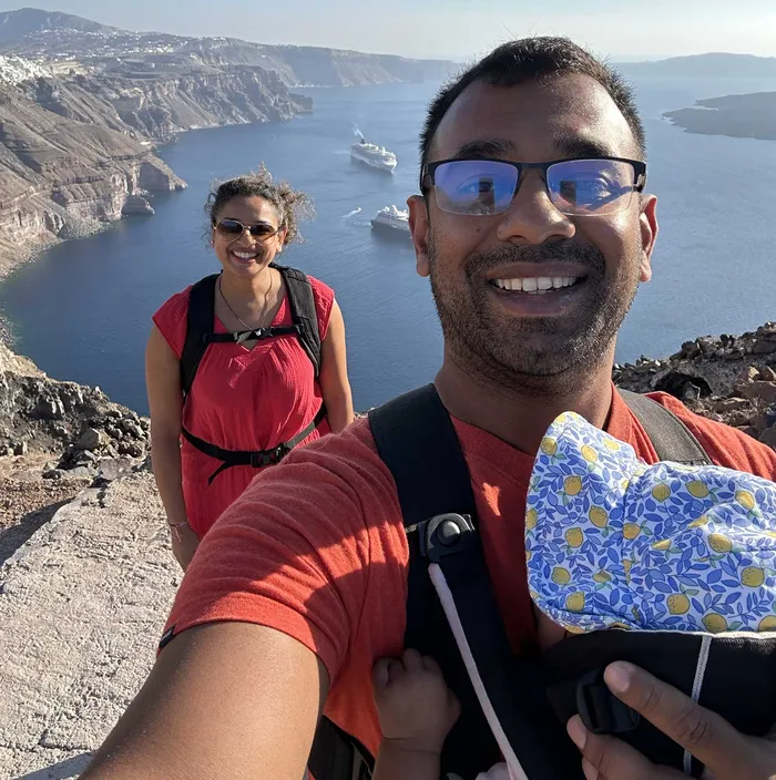 Terence Meghani hiking with family overlooking the Santorini caldera